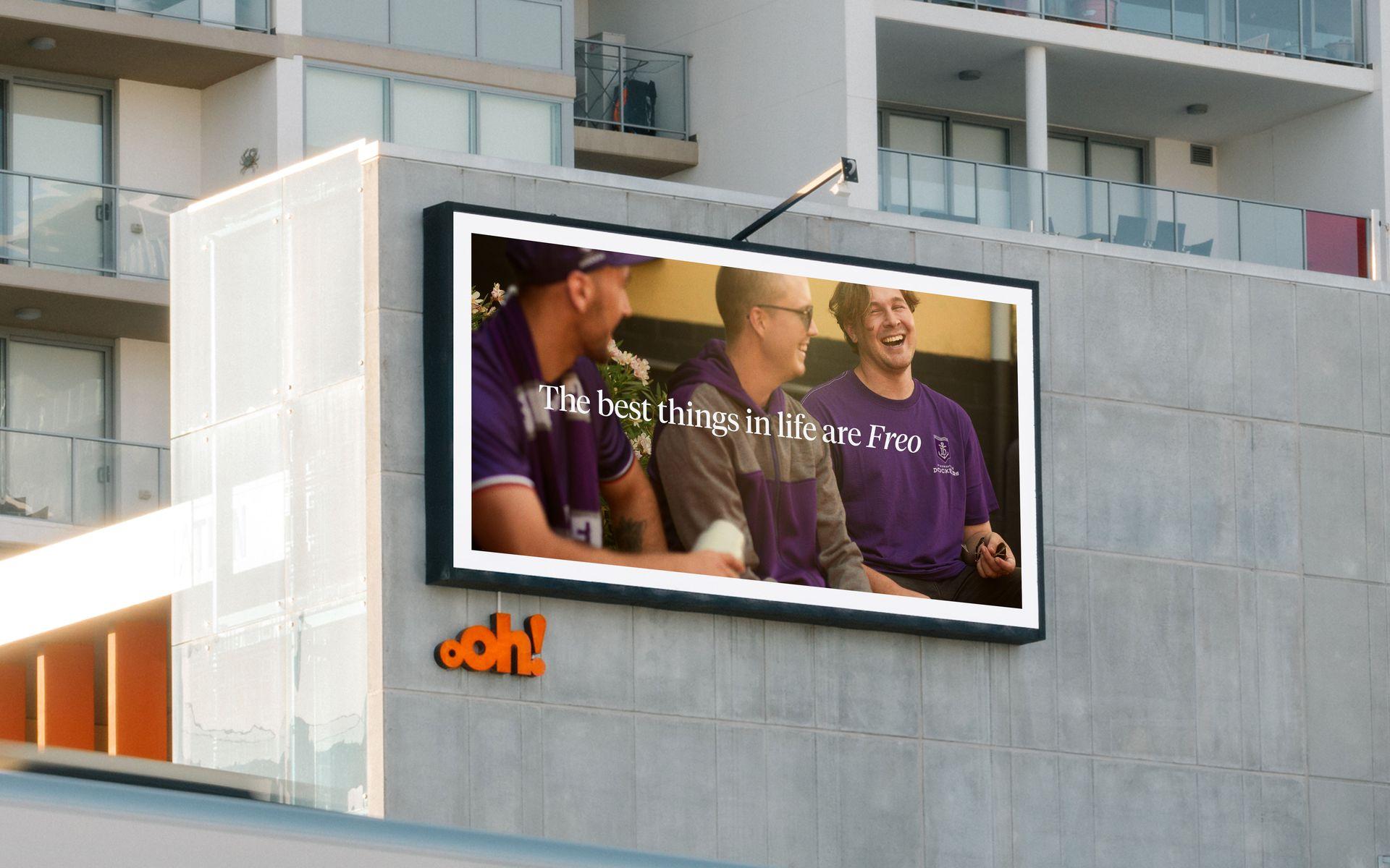 Bilboard with 3 people in purple in the background, with "The best things in life are freo" text in foreground"